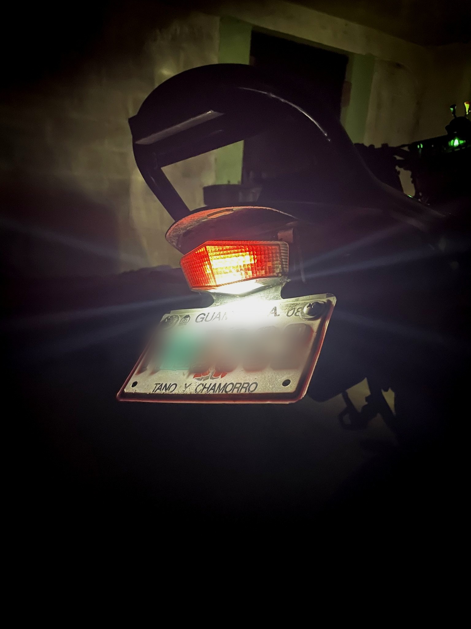 The reprinted clear piece fitted on the DRZ400 at night, plate light shining through